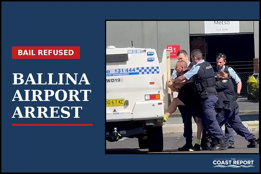 Police officers restraining Braden Hardy beside a police vehicle at Ballina Byron Gateway Airport